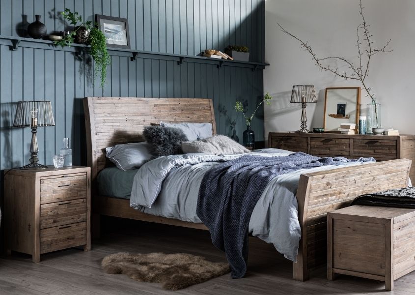 solid wooden bed with dark blue painted wooden panelling