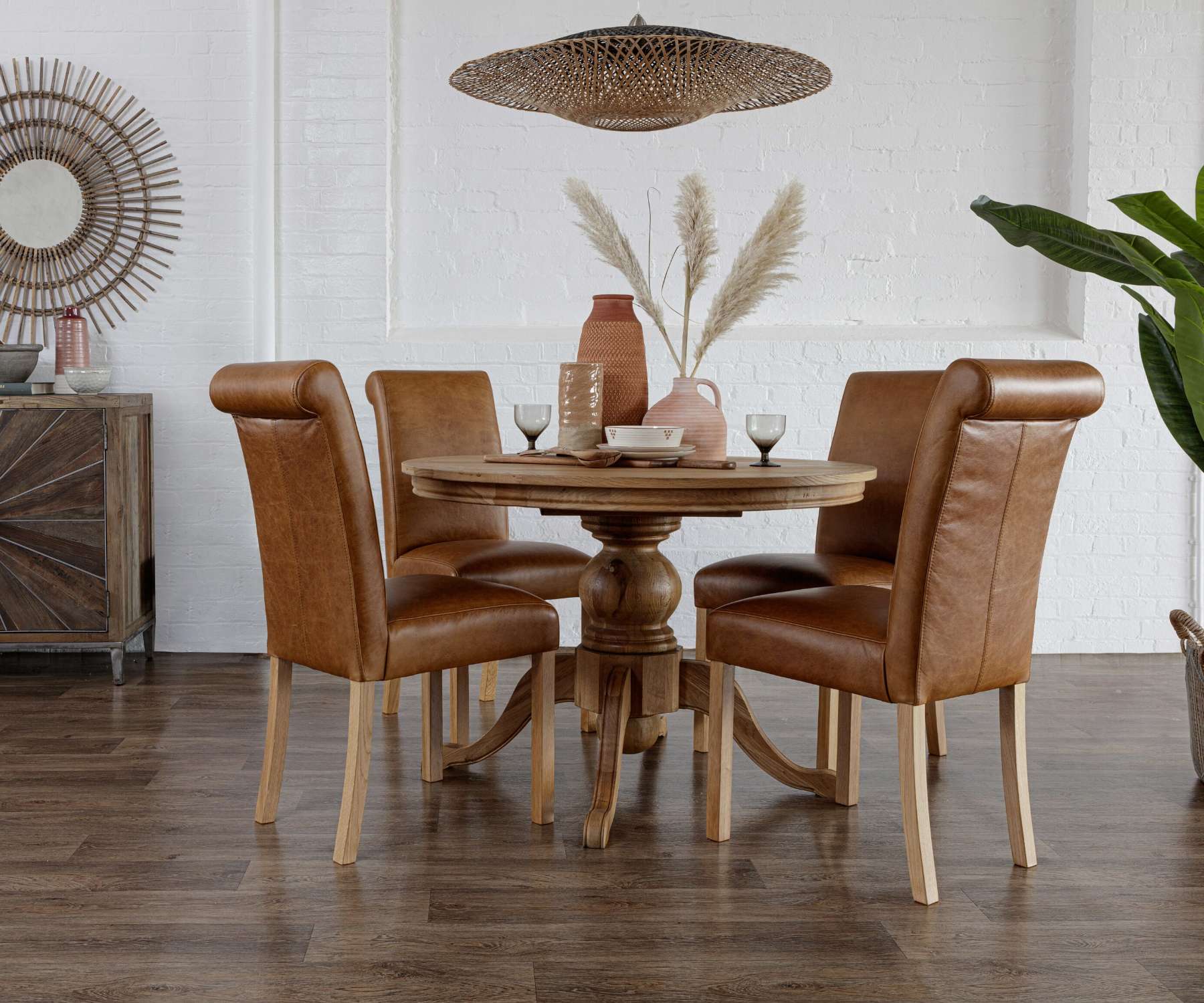 oak round dining table with brown faux leather chairs
