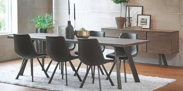 Industrial oak dining table with six dark grey dining chairs and matching wooden sideboard