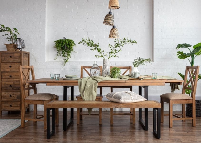 Reclaimed wood dining table with black steel legs and matching wooden bench and dining chairs with bamboo hanging pendant light