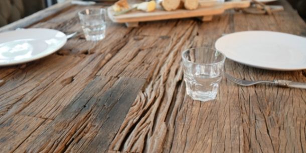 rustic reclaimed wood dining table with small glass
