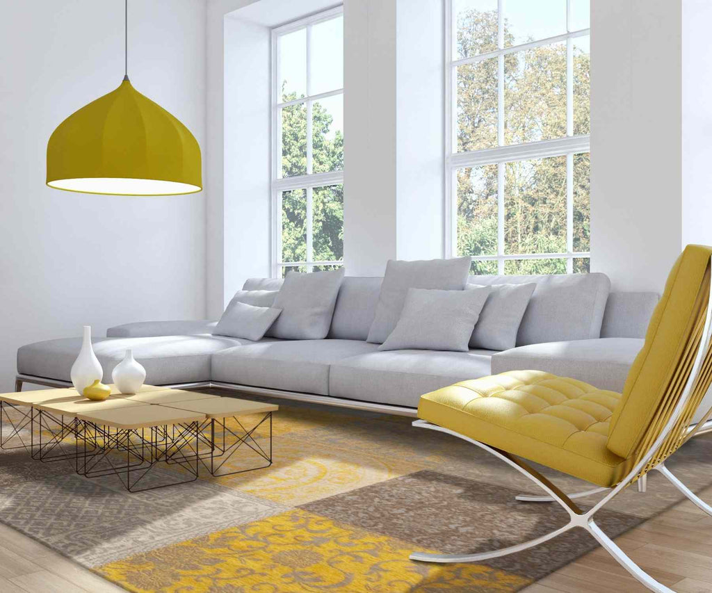 Living room with white sofa and yellow coloured pendant light, rug and armchair