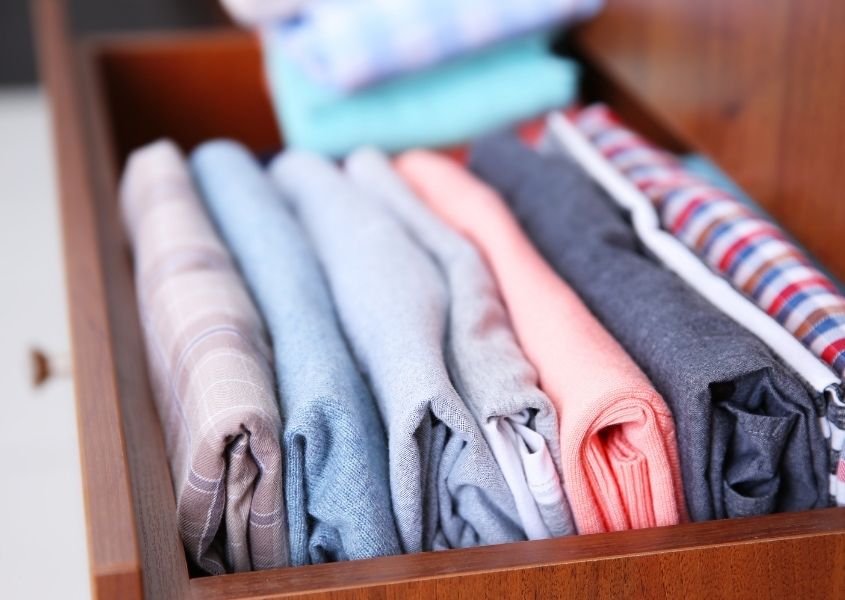 clothes neatly folded in chest of drawers for 5 ways to get better at decluttering blog