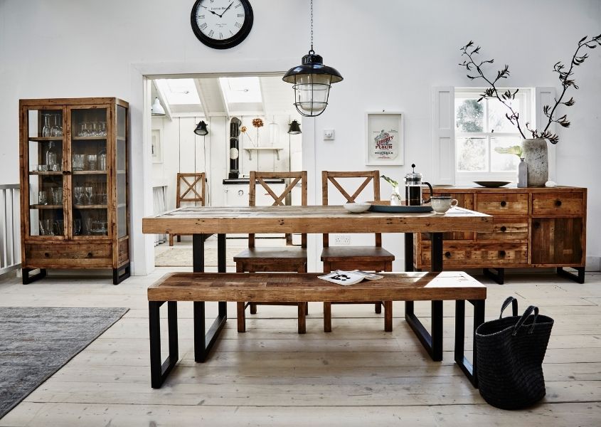 Industrial dining table with matching wooden bench in white dining room with other rustic wood furniture