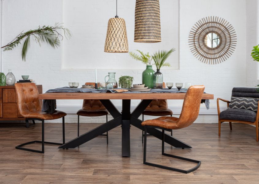 solid oak dining table with black metal spider leg and brown leather dining chairs