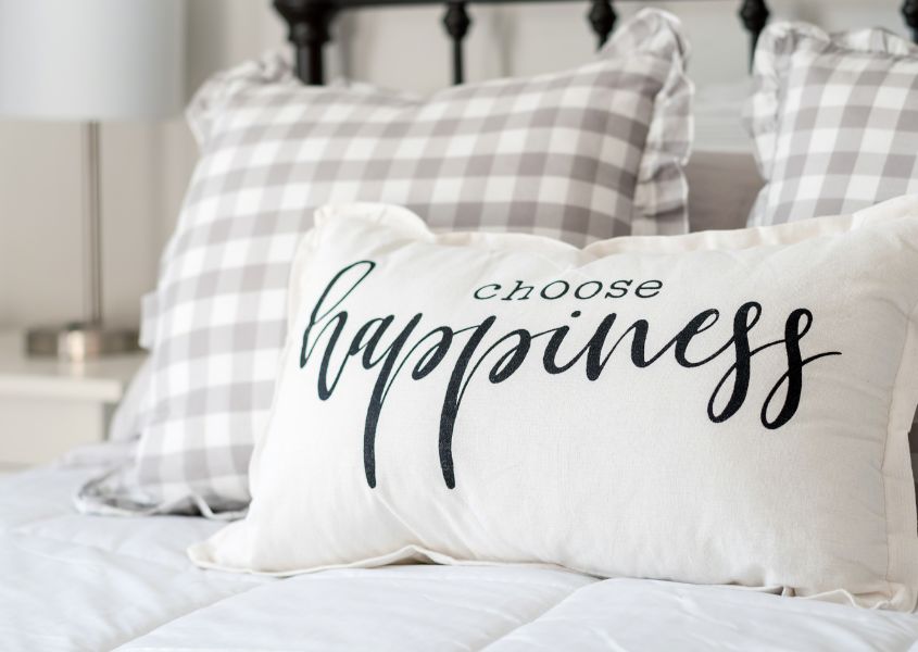 bed cushion with happiness written on it for 6 styling tips for a feel-good bedroom