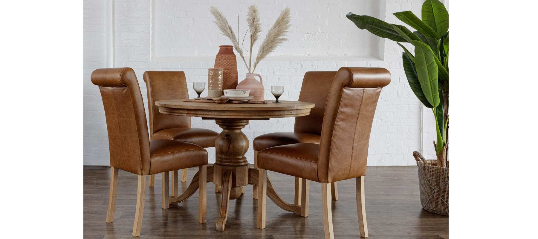 Round dining table with brown leather chairs