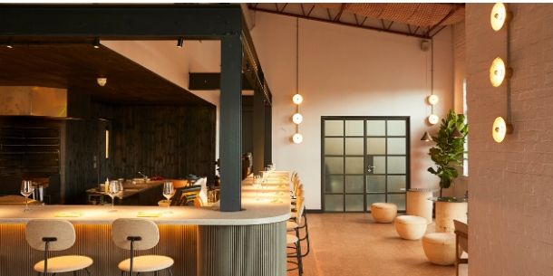 Bar area of Silo London with wall lights and cream bar stools