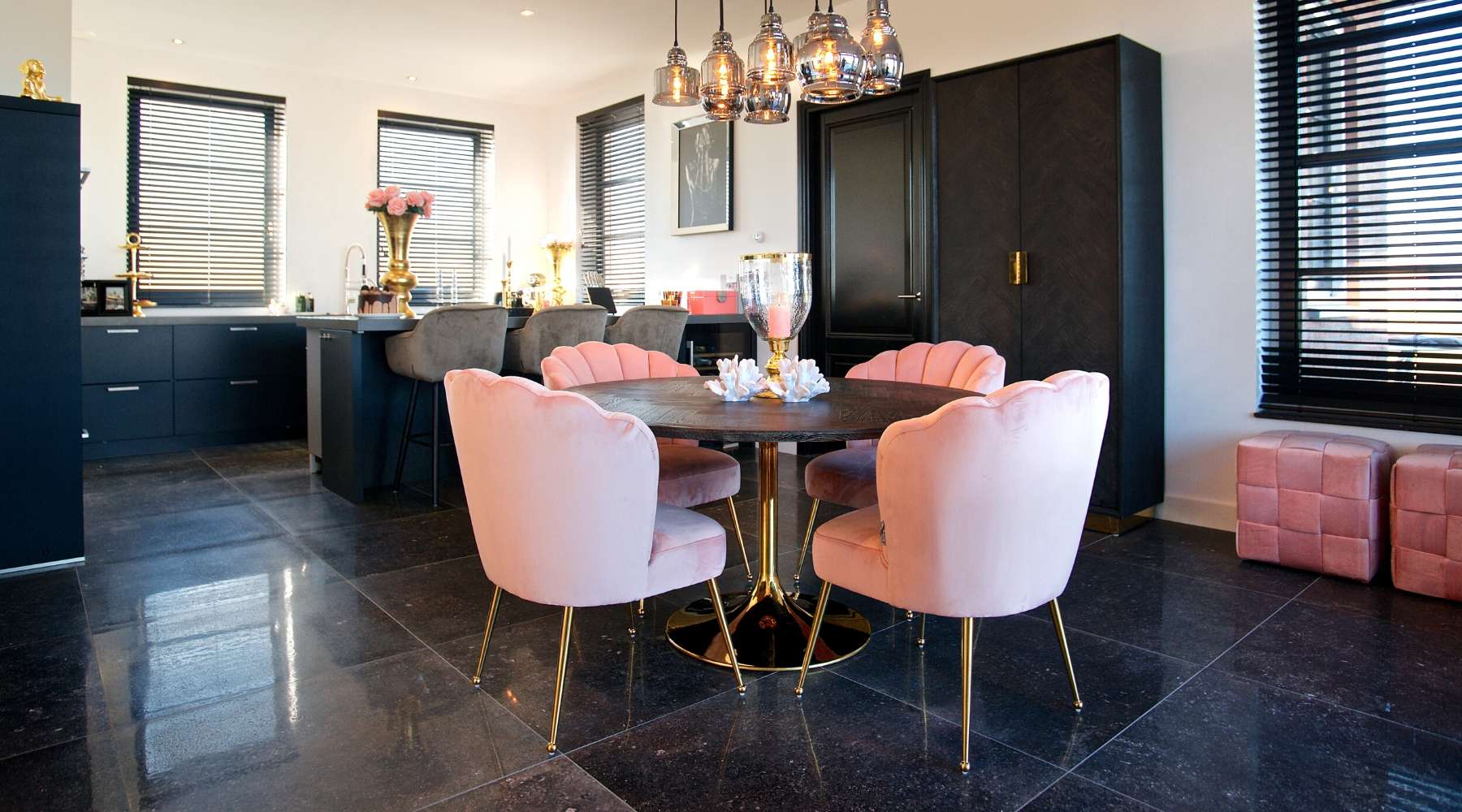 dark kitchen with dark round table and pink chairs
