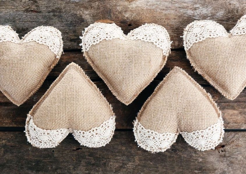 small cushioned hearts on top of a rustic dining table