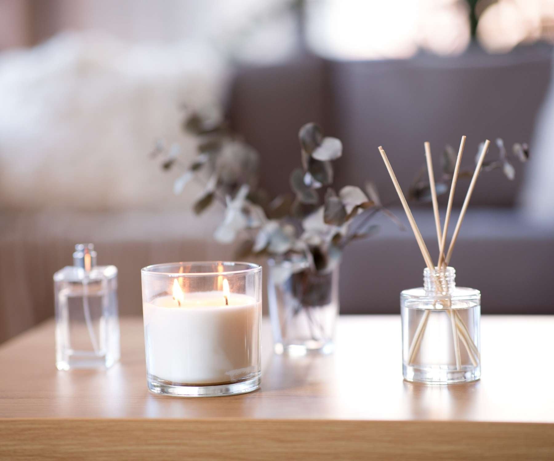 scented candles and diffuser on a wooden coffee table