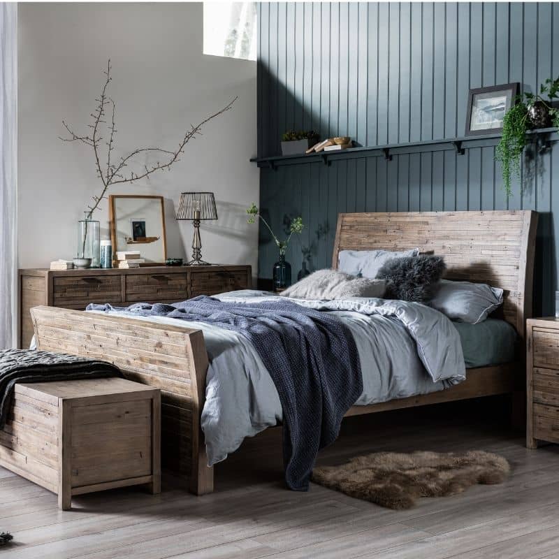 Rustic wooden bench at foot of boho bed