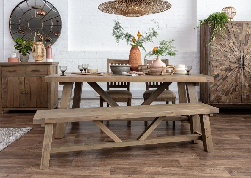 Reclaimed wood dining table decorate with terracotta vase and wooden sideboards in background