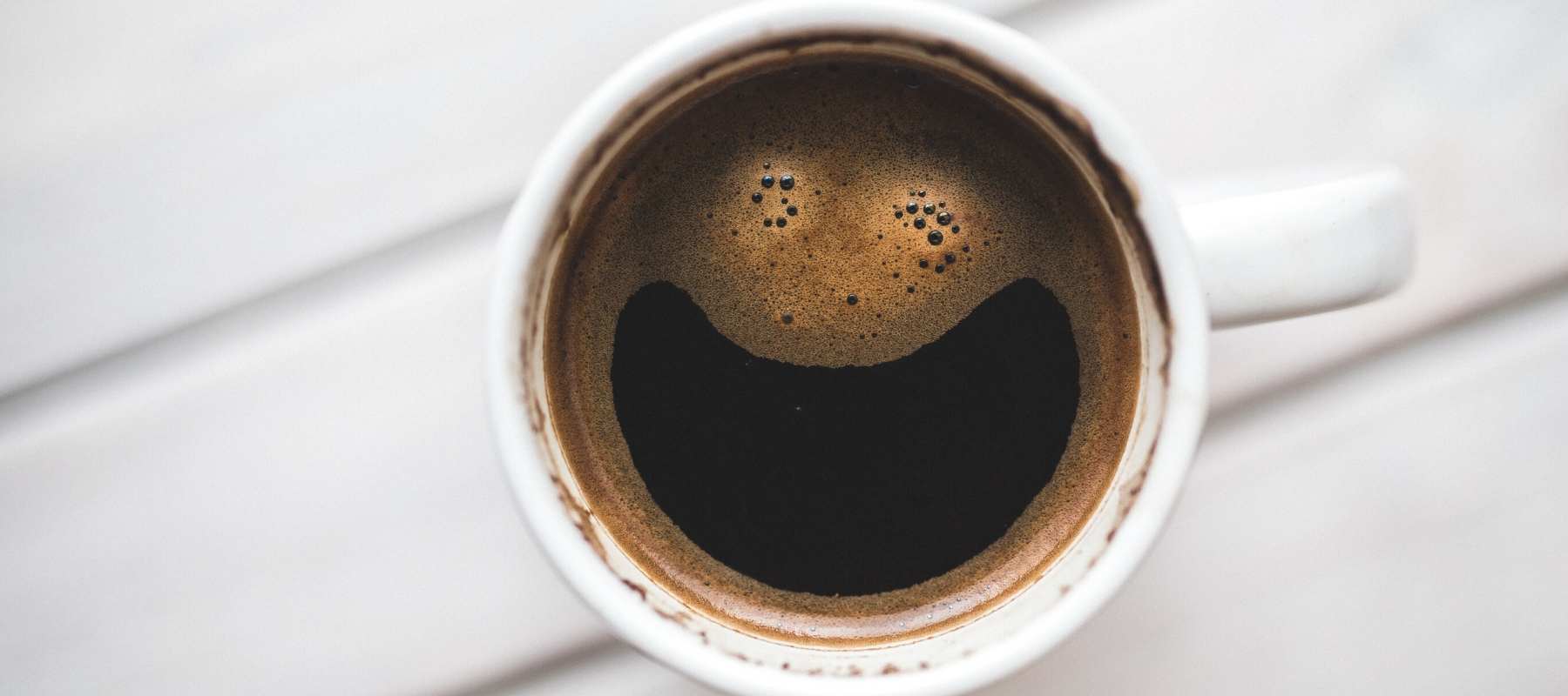 Cup of black coffee with smiley face