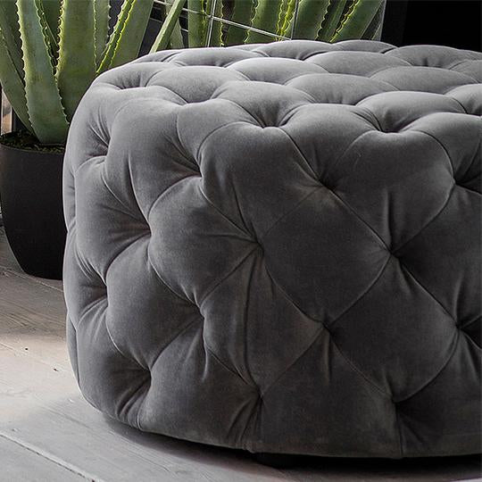 Grey buttoned footstool in soft velvet fabric