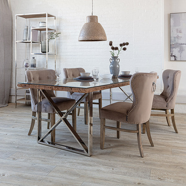 Reclaimed wooden dining table with a glass tabletop and cream velvet dining chairs