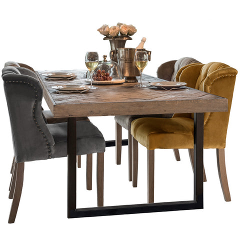 Sturdy wooden dining table on black metal square legs with dining chairs and decor