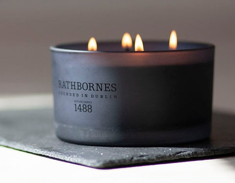 A Rathbornes scented candle in a black jar