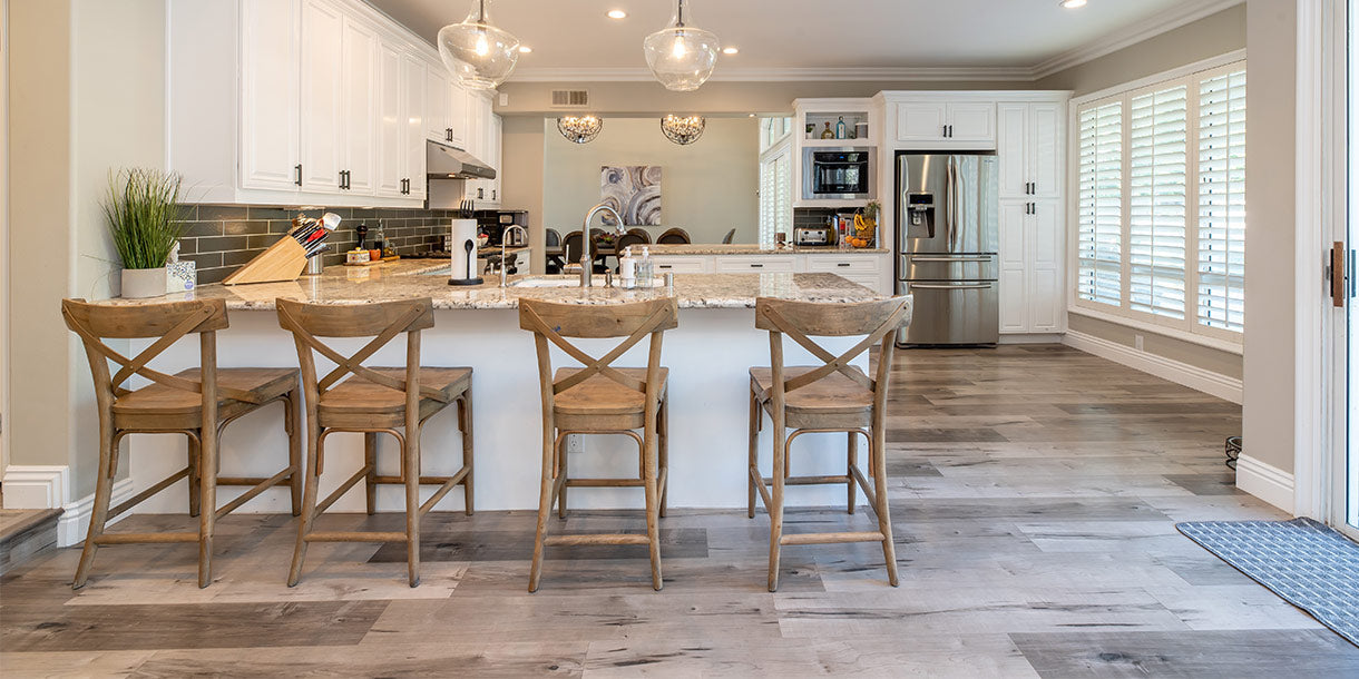 Four wooden bar stools in front of a kitchen island in an open plan home