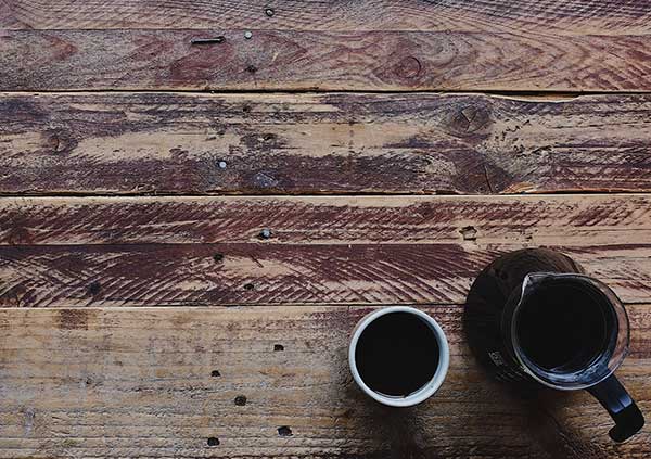 Two cups of coffee on top of a reclaimed wooden surface