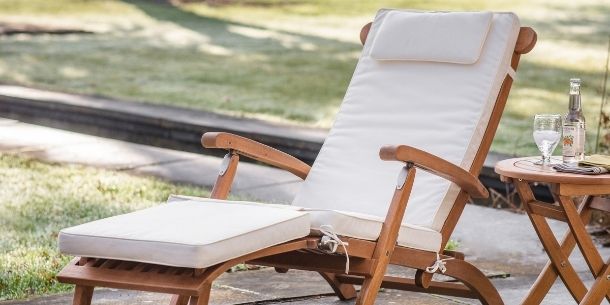 garden lounge chair with white cushion and wooden side table