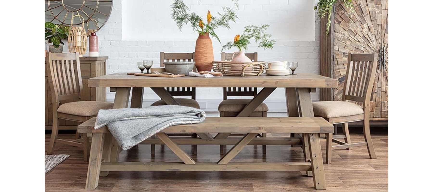 Wooden trestle table with wooden bench and terracotta vase