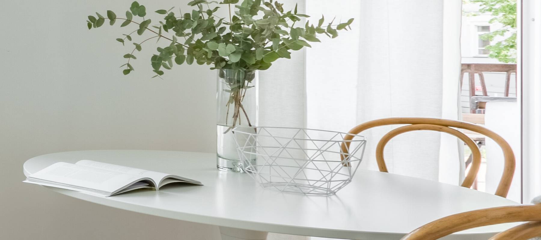 White oval table with green plant