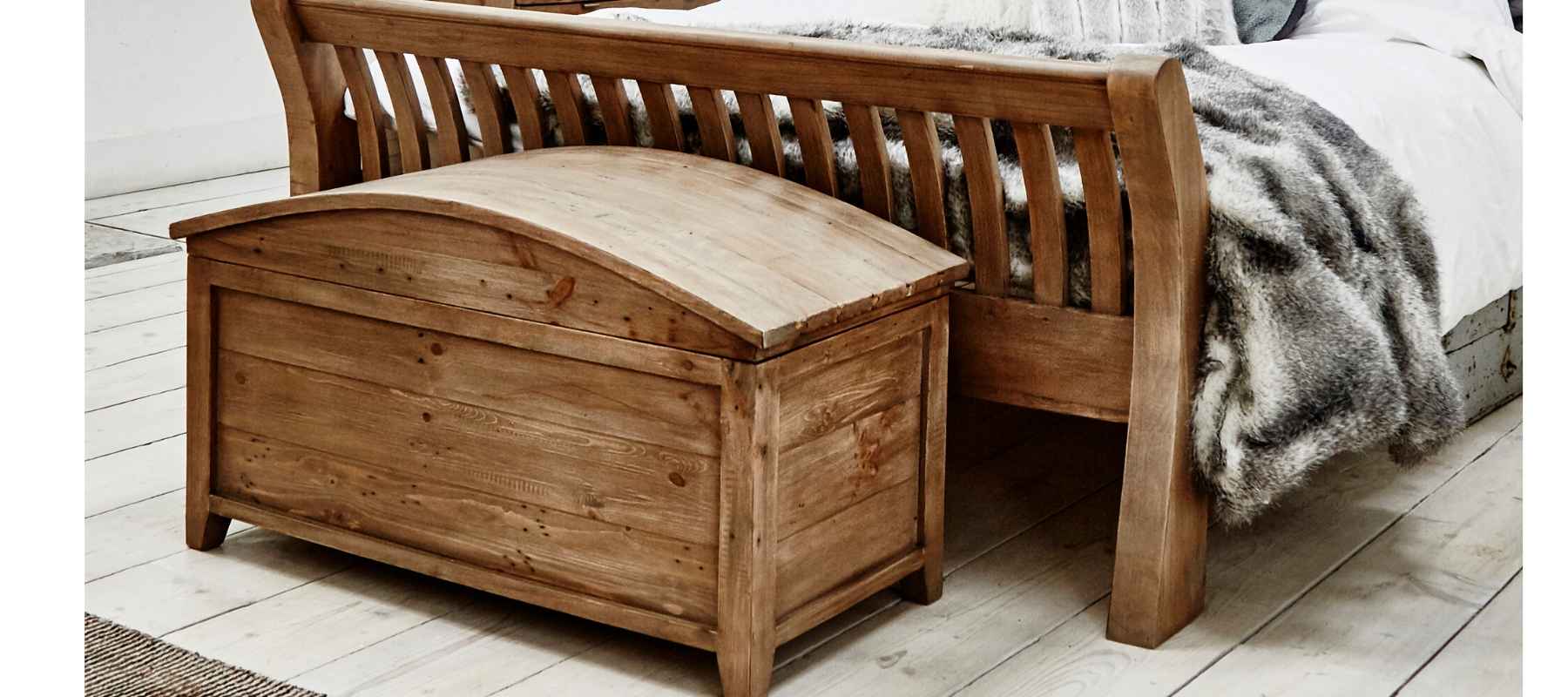 Wooden blanket chest in front of reclaimed wood bed
