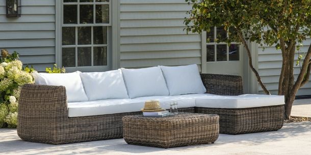 Rattan corner sofa with matching coffee table and white cushions