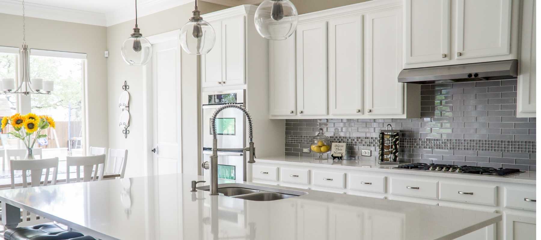 White kitchen with glass hanging pendants