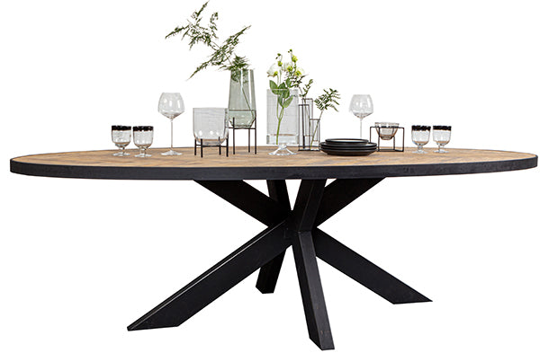 An oval, industrial dining table with spider legs