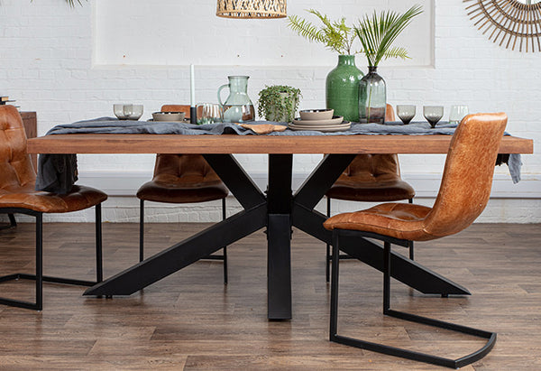 Industrial oak dining table with black steel spider legs and industrial dining chairs