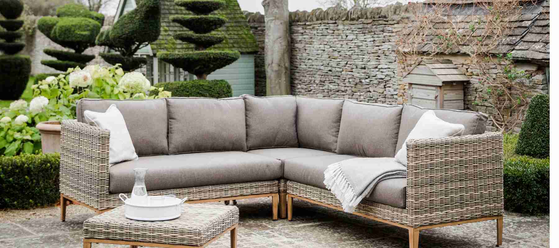 Rattan corner sofa with neutral cushions