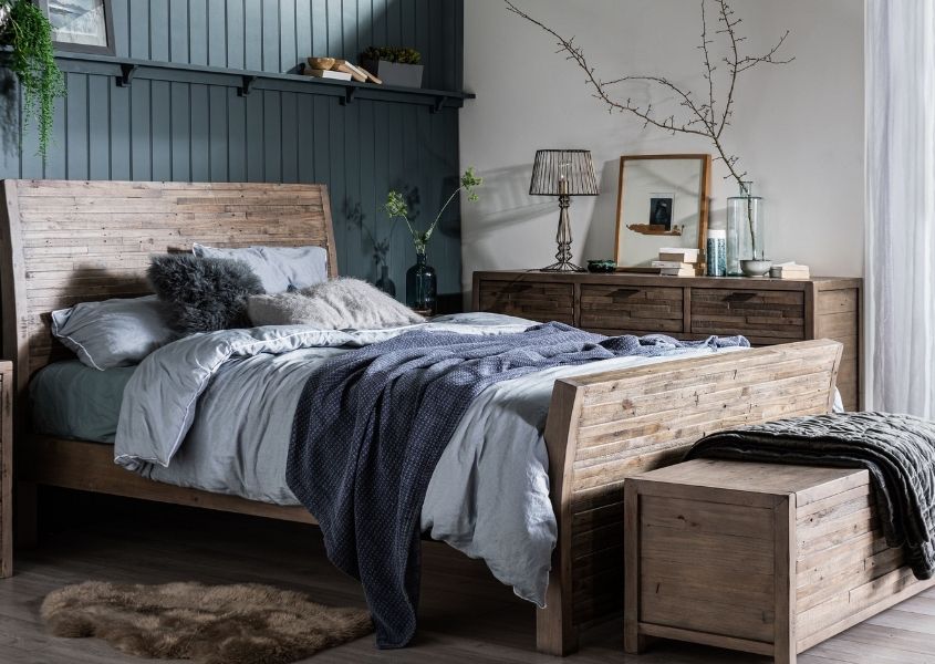solid wood bed with dark grey painted wall