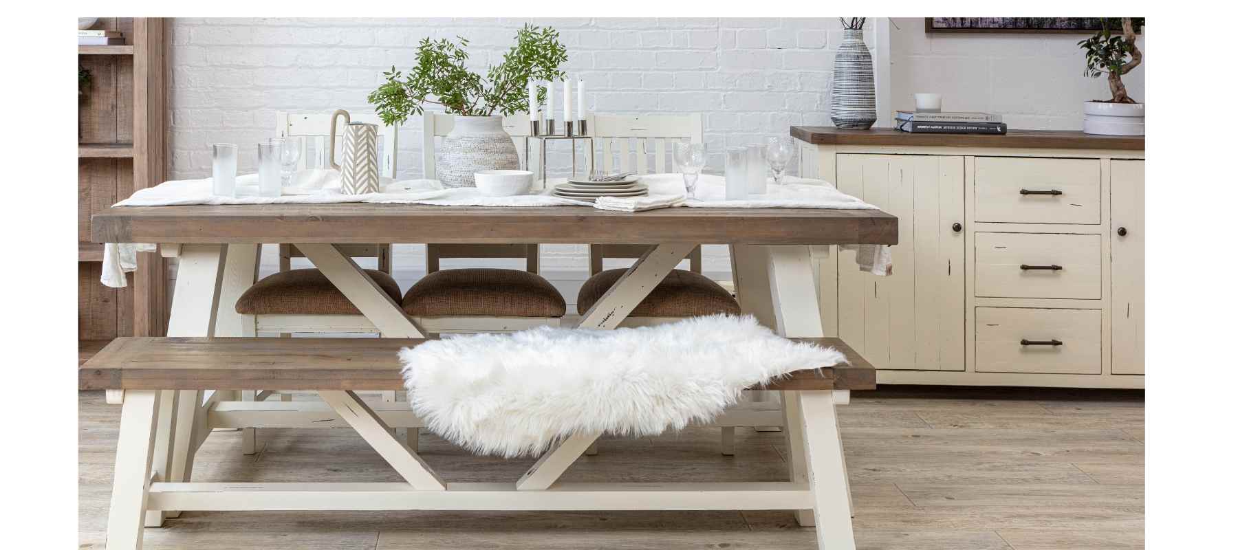 Farmhouse style wooden table with white legs and matching wooden dining bench