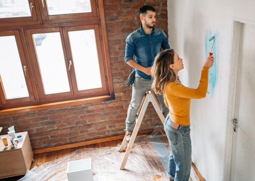 couple painting a wall for a quick guide to painting and decorating in a weekend blog
