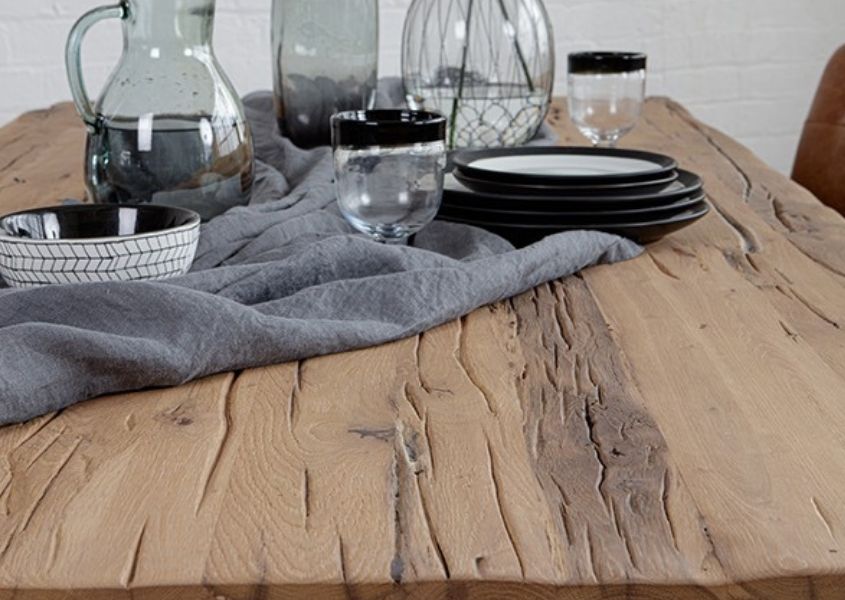 Close up of reclaimed wood dining table with grey linen runner