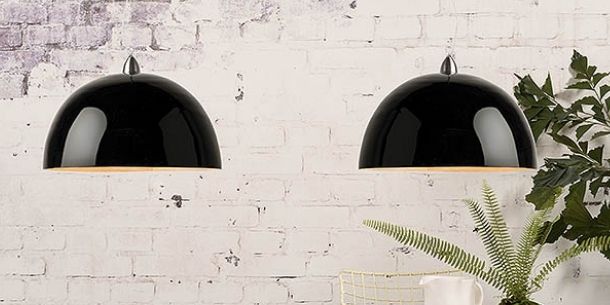 Black double pendant light against white painted exposed brick wall