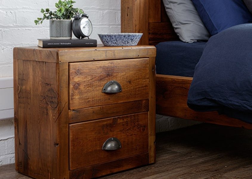 Reclaimed wood bedside table with two drawers and metal handle with small plant pot on top