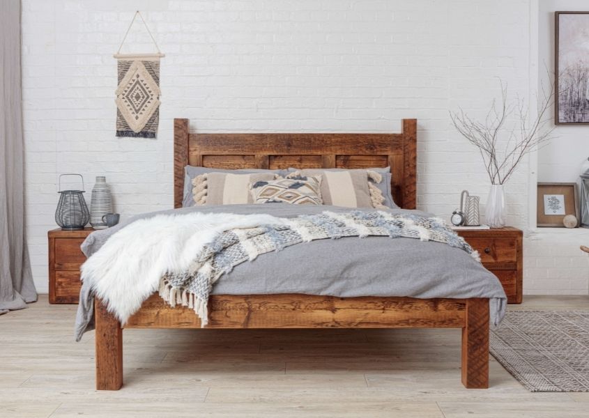 king size wooden bed frame with grey covers and matching wooden bedside tables