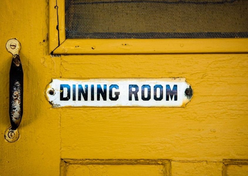 yellow wooden door with dining room sign