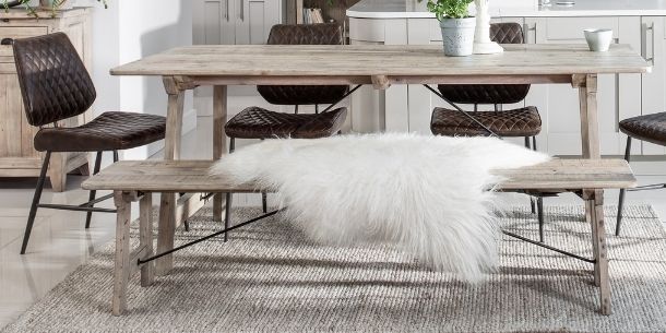 Reclaimed wood dining table with matching dining bench and sheepskin throw