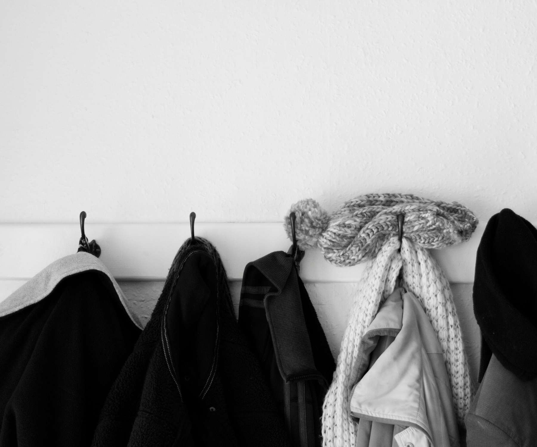 coats hanging on wall hooks