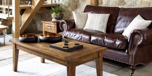 mango wood coffee table next to dark brown leather sofa