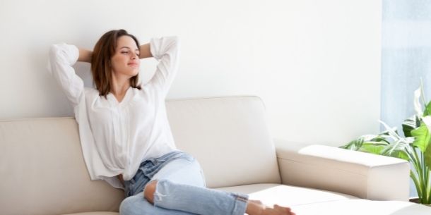 lady relaxing on a white sofa for create an interior that's good for you and the planet blog