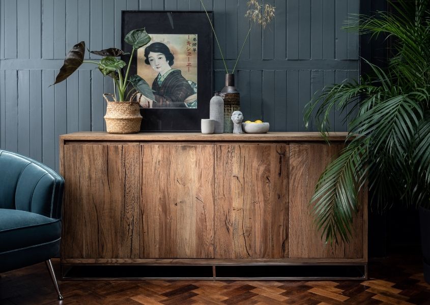 reclaimed wood sideboard with green palm and petrol blue velvet armchair