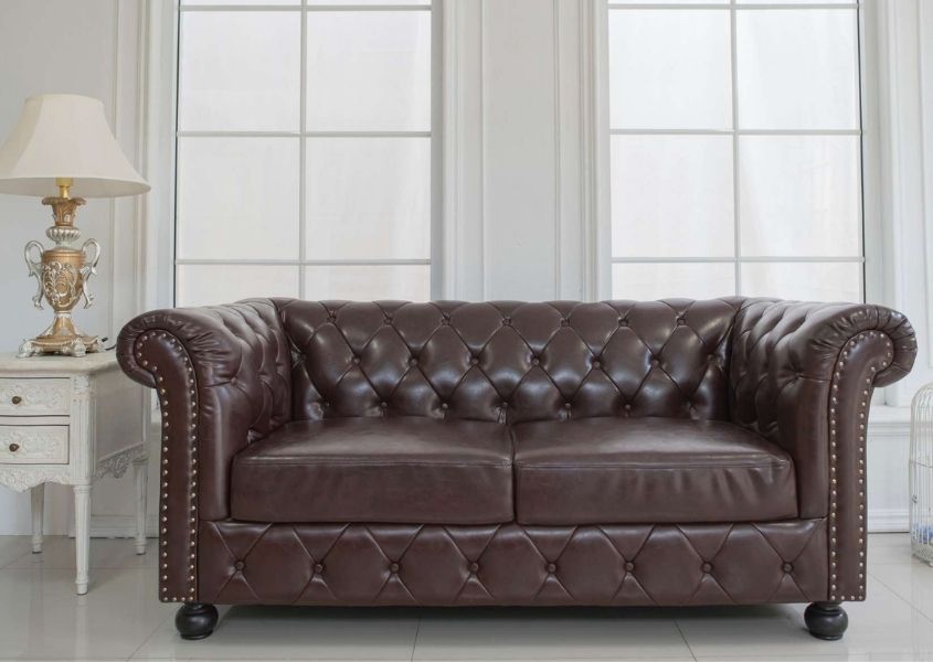 brown leather chesterfield sofa in white living room