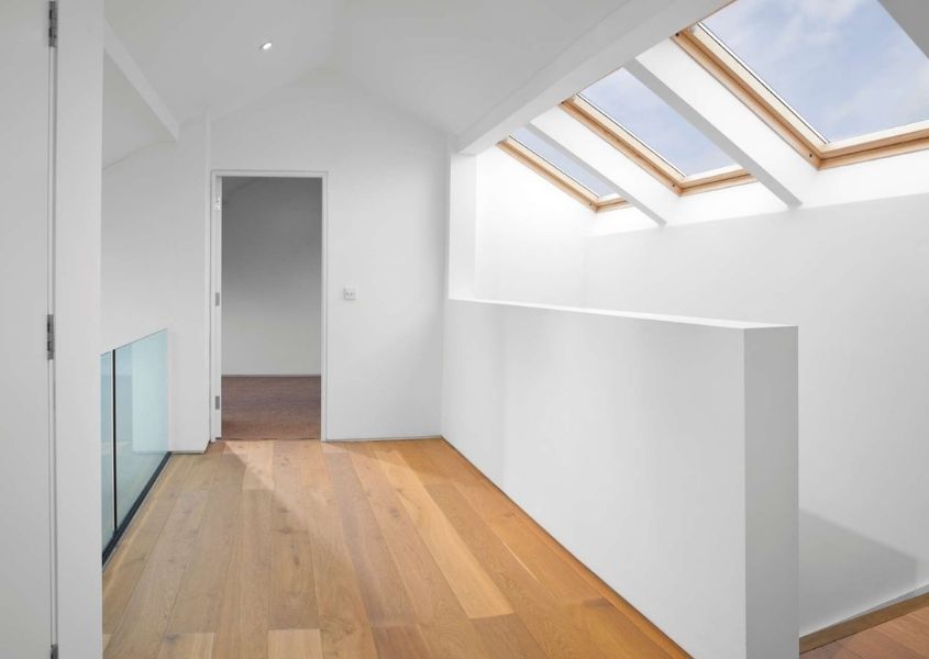 Internal shot of loft conversion with three skylights, white painted walls and wooden floor