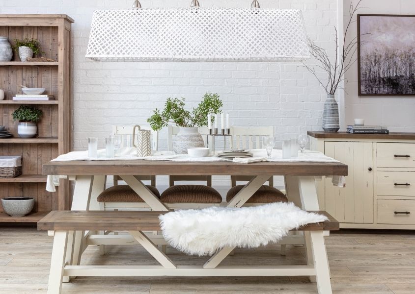 Wooden dining table with white trestle legs and matching wooden bench