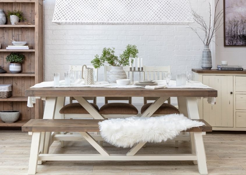 Reclaimed wood dining table with white painted trestle legs and matching wooden bench